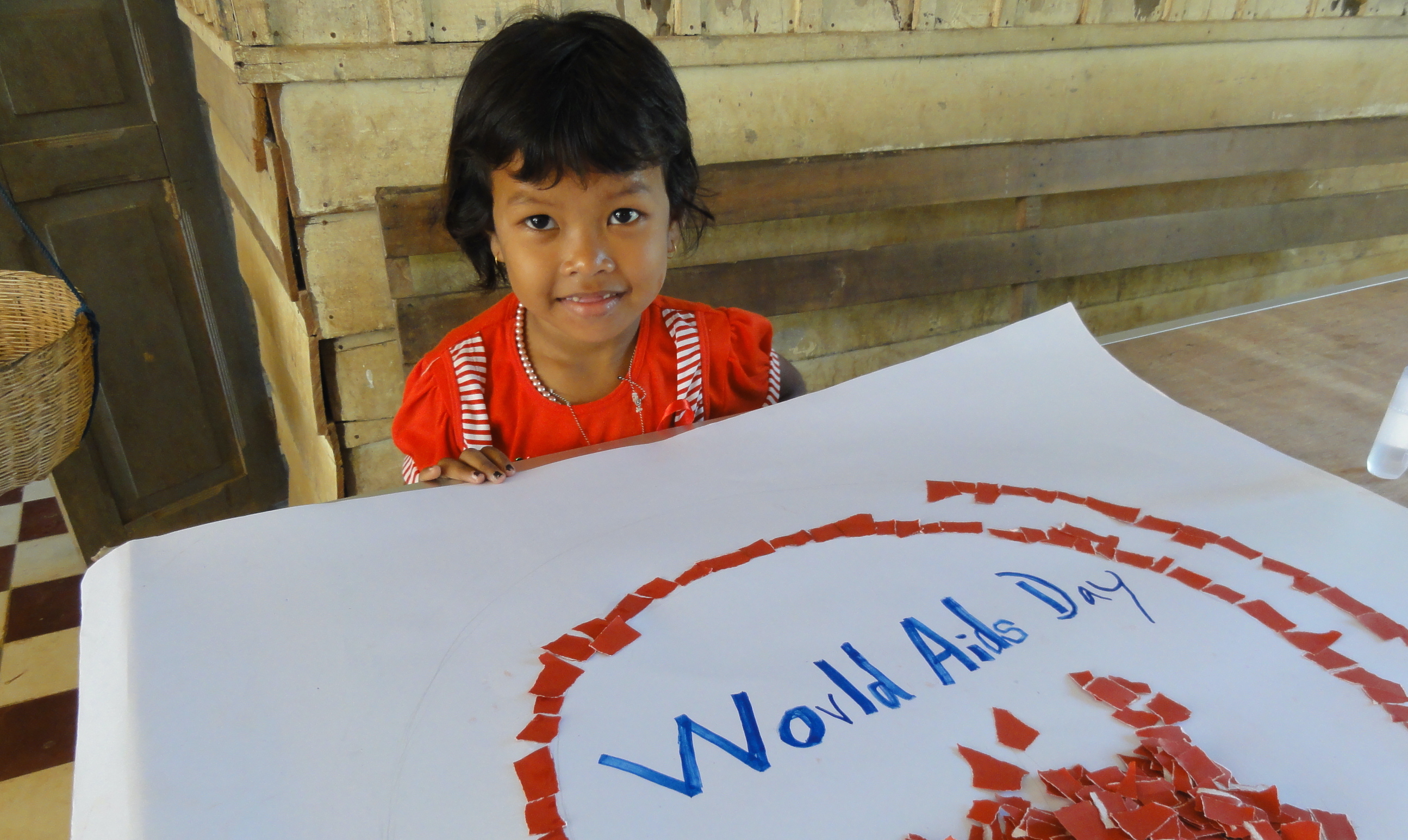 Young girl holding poster with HIV/Aids ribbon, World Aids Day 2011, Cambodia, PC Digital Library
